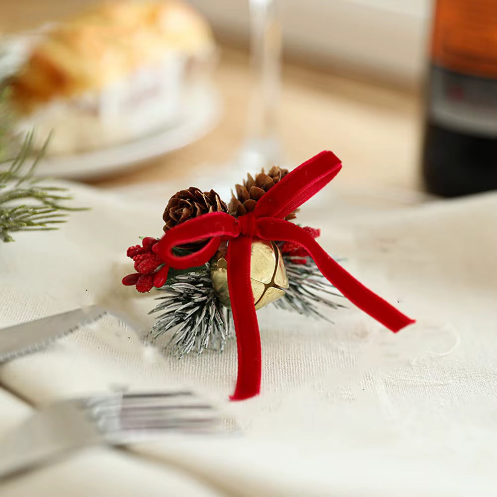 Anneau de serviette en forme de cloche de noël avec nœud papillon, avec pomme de pin de fruits rouge